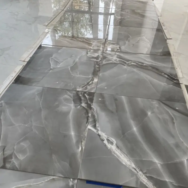 Instalación de losas de mármol gris oscuro con vetas naturales en proceso de colocación con juntas perfectas en proyecto de Campeche
