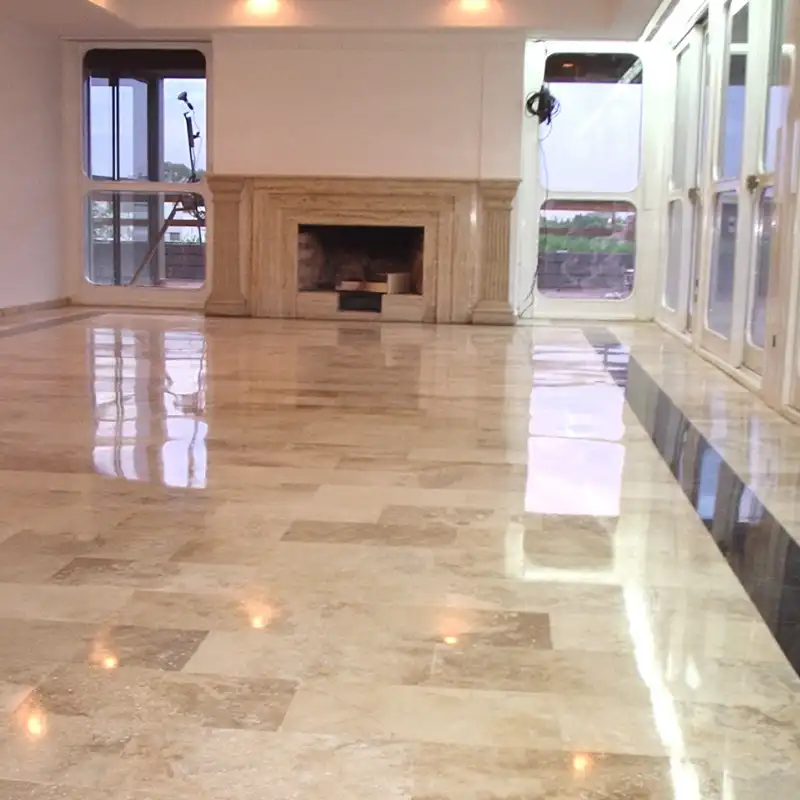 Restauración completa de 850 m² de mármol italiano con acabado espejo en residencia de alto standing en el Obispado, Monterrey, Nuevo León — Pulistone Sala principal de residencia de lujo en el Obispado, Monterrey, Nuevo León, con piso de mármol travertino italiano restaurado a espejo por Pulistone mediante pulido de mármol y sellado de pisos profesional, mostrando reflexión perfecta de luz natural y chimenea de cantera
